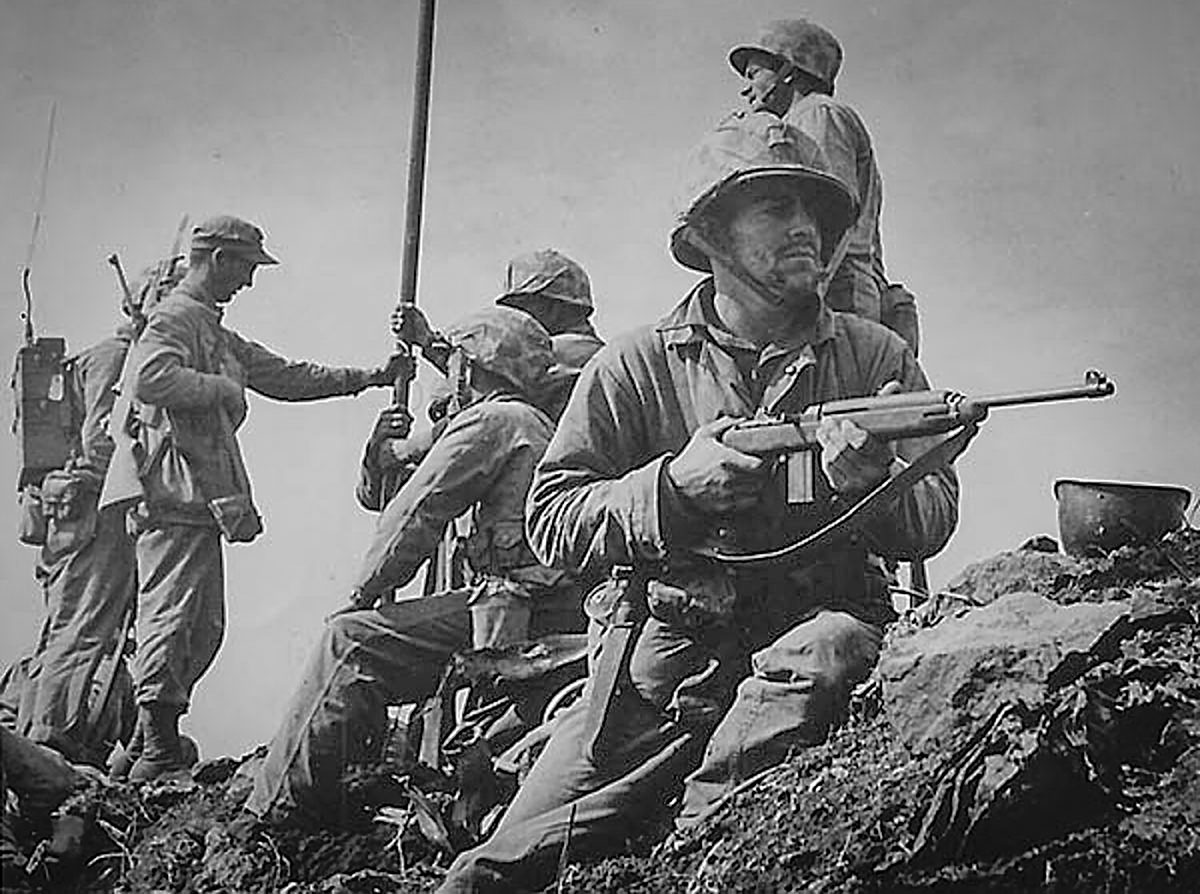 Two M1 Carbines are visible in this 1945 photo taken on Iwo Jima, Japan. Such swords were later turned into plowshares when re-barreled to 22 Spitfire for civilian use. (National Archives photo)